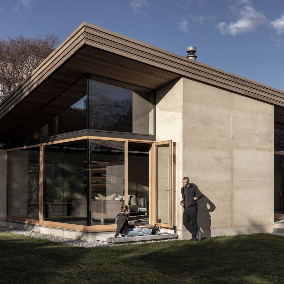 The rammed earth house with a curved roof that lifts toward the sun