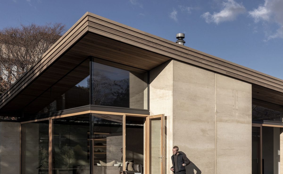 The rammed earth house with a curved roof that lifts toward the sun