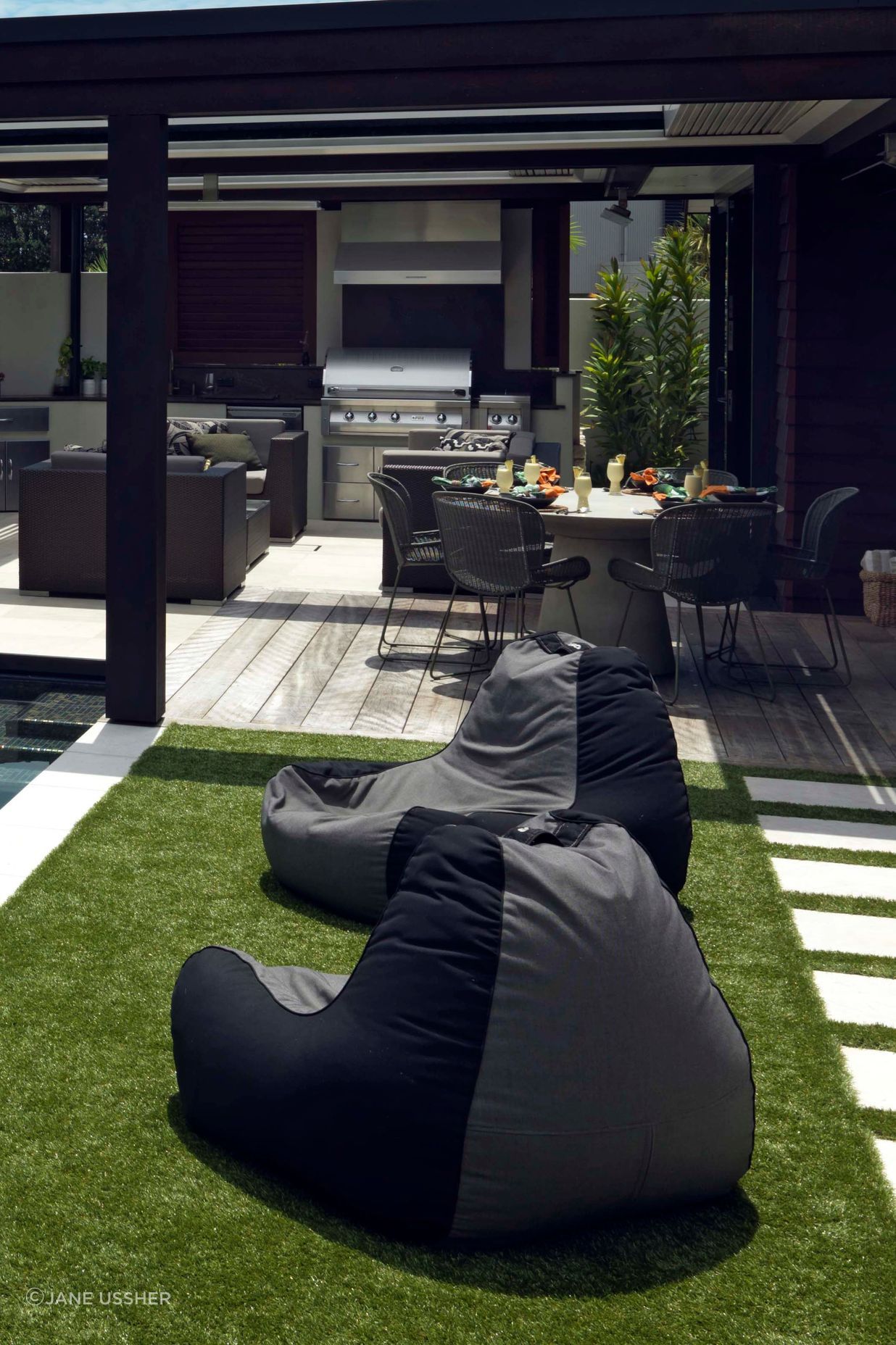 The outdoor kitchen and dining areas are adjacent to low-maintenance turf.