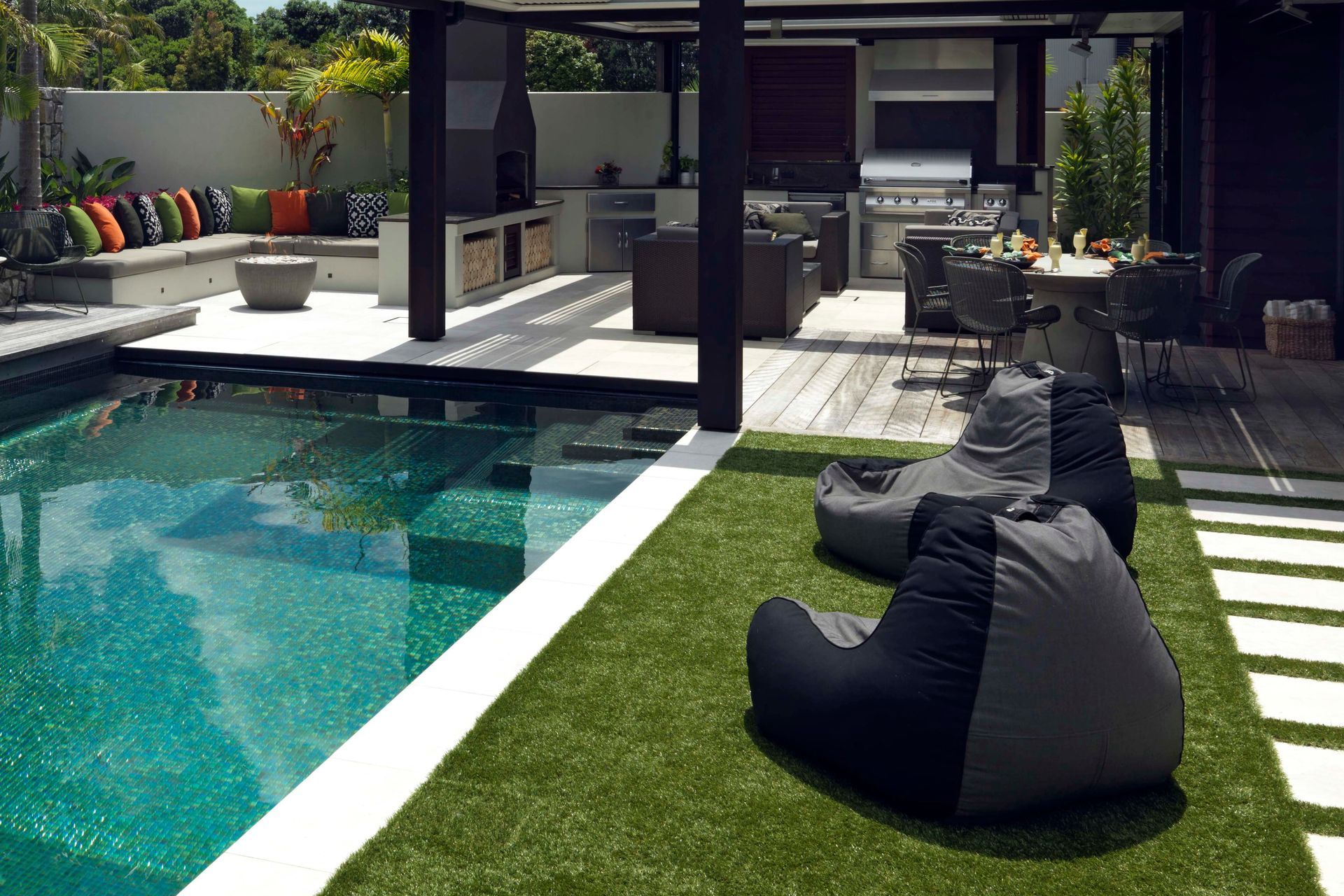 The outdoor kitchen and dining areas are adjacent to low-maintenance turf.