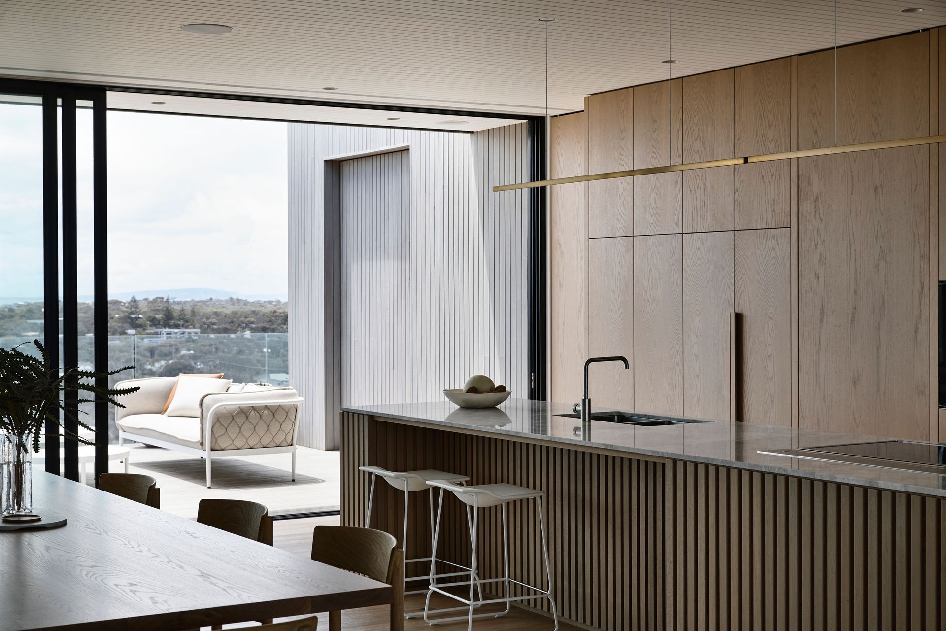 The seamless timber kitchen cabinetry warms the space.