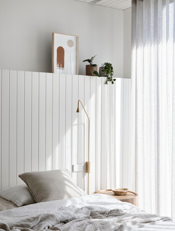 A timber lined ceiling and timber headboard offer a subtle coastal reference in the master bedroom.