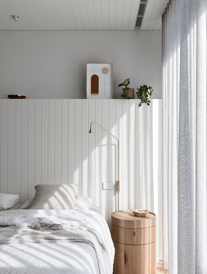 Soft linens in greys and whites filter are enhanced by floor length drapes that filter the light.