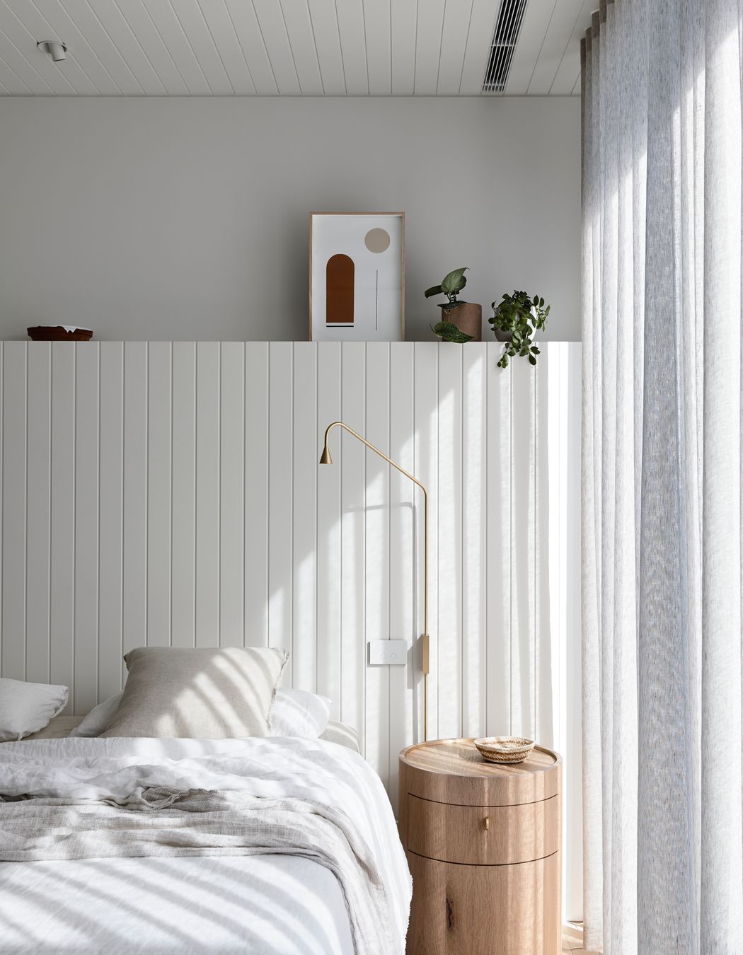 Soft linens in greys and whites filter are enhanced by floor length drapes that filter the light.