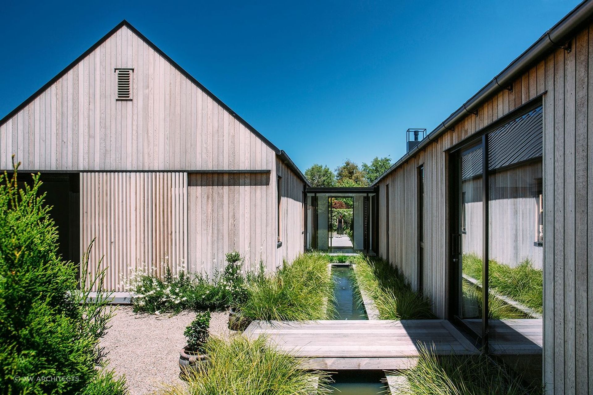 The rill between the two structures complements the home's riverside setting. | Photography: Lisa Gane