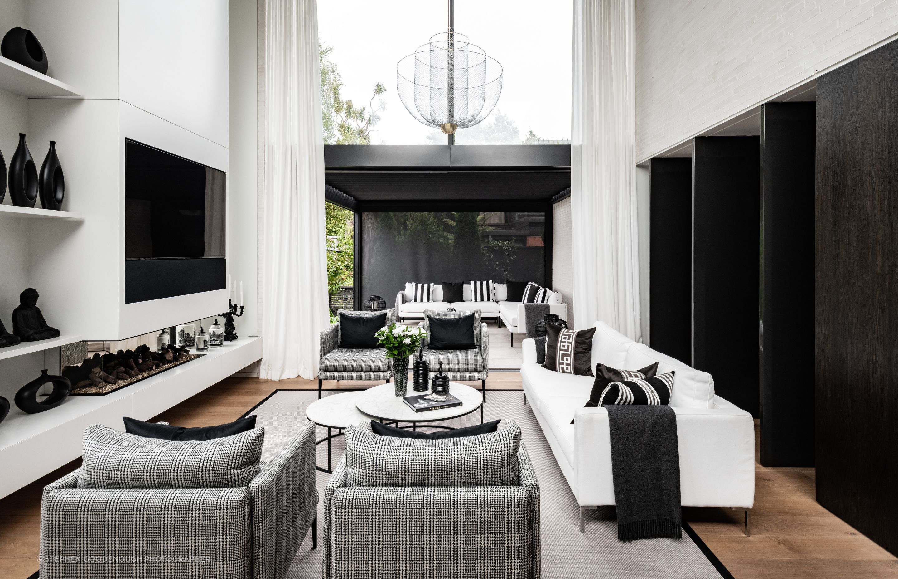 The living area leads straight out to a louvred outdoor room, and through the pivoting doors on the right is a private sitting room and the master bedroom. "The clients loved the simple black and white colour palette but then we've used timbers to warm it up a little.”