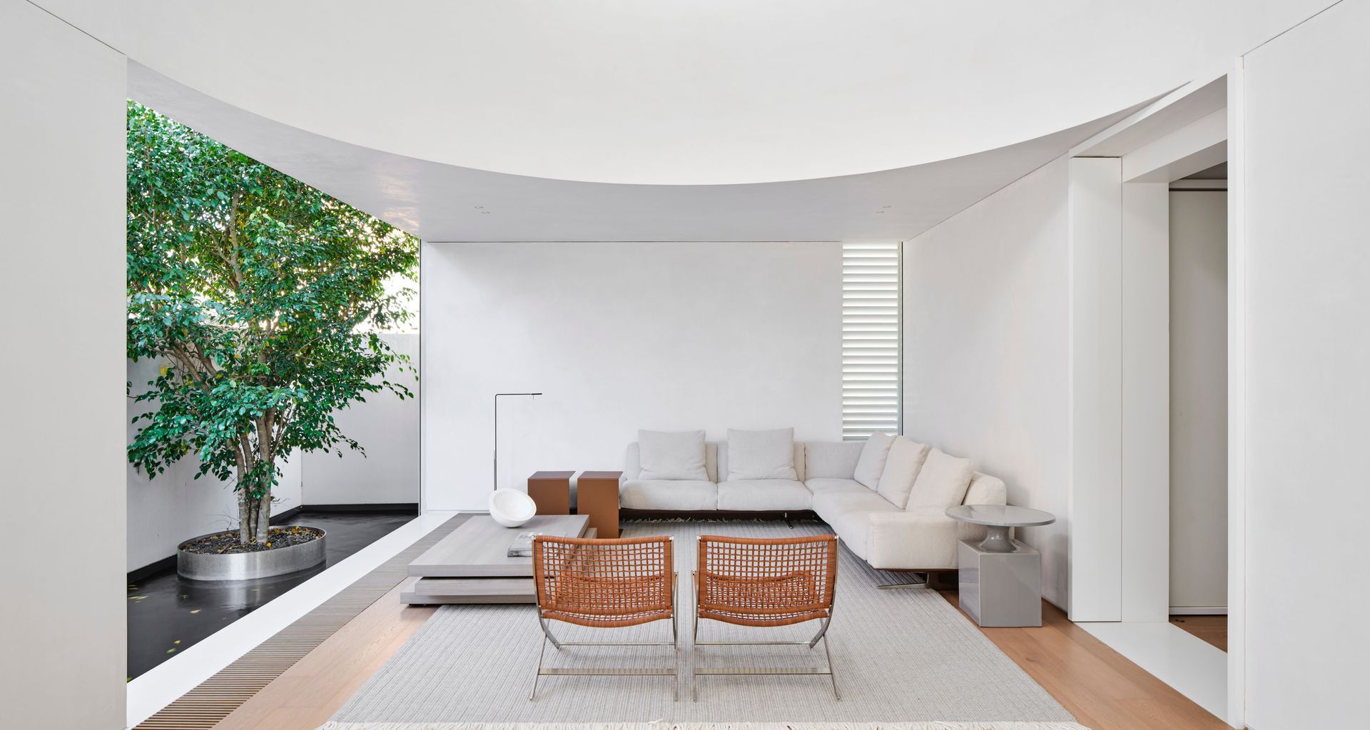 The curved balustrade that closes off the mezzanine study overlooking the main living space injects drama into the double-height volume. Image credit: Romello Pereira