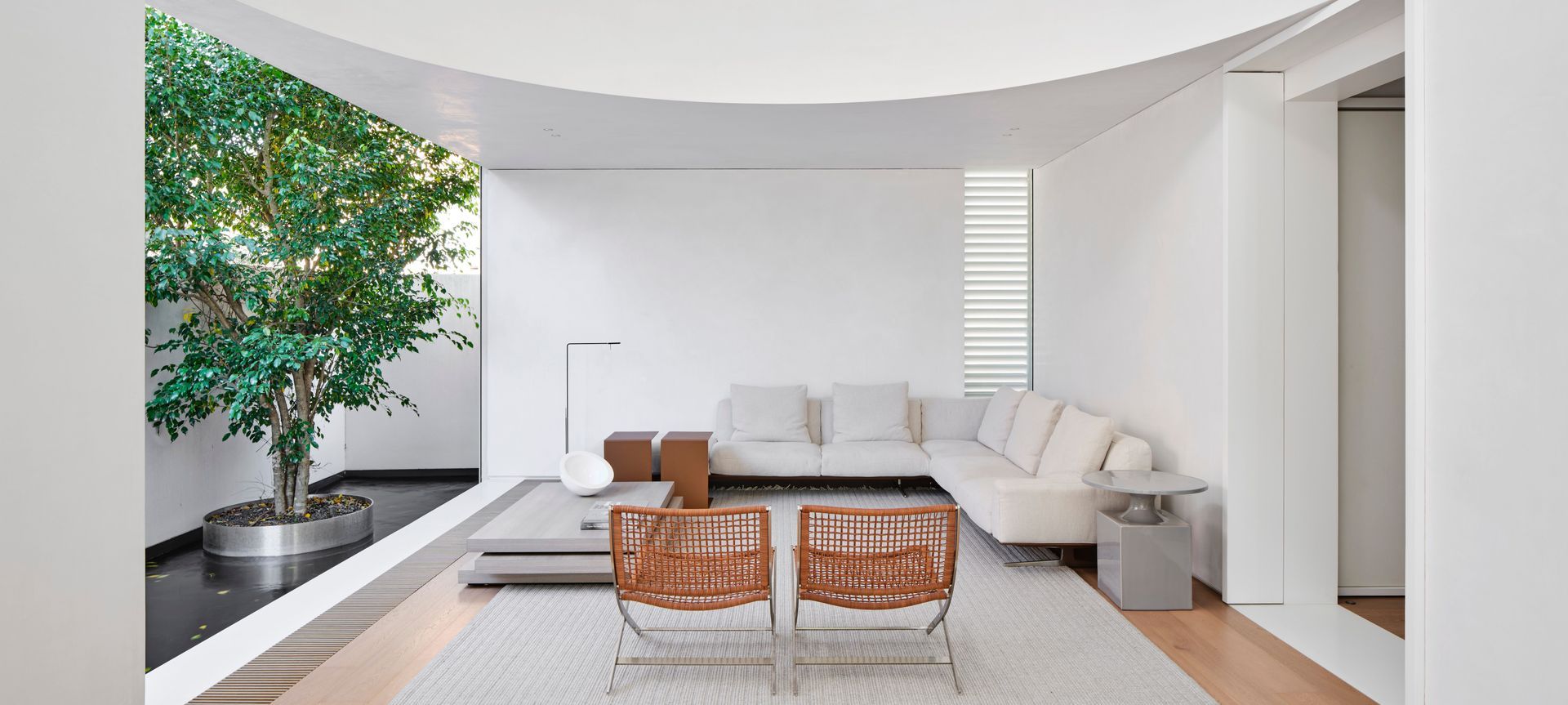 The curved balustrade that closes off the mezzanine study overlooking the main living space injects drama into the double-height volume. Image credit: Romello Pereira