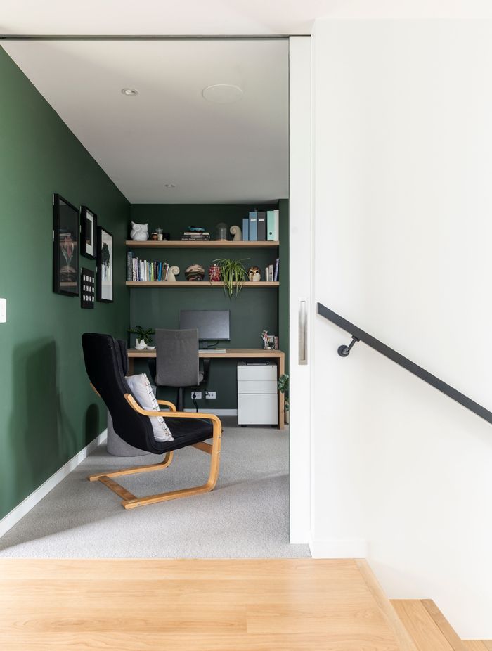 An office space features calm, forest-green walls.