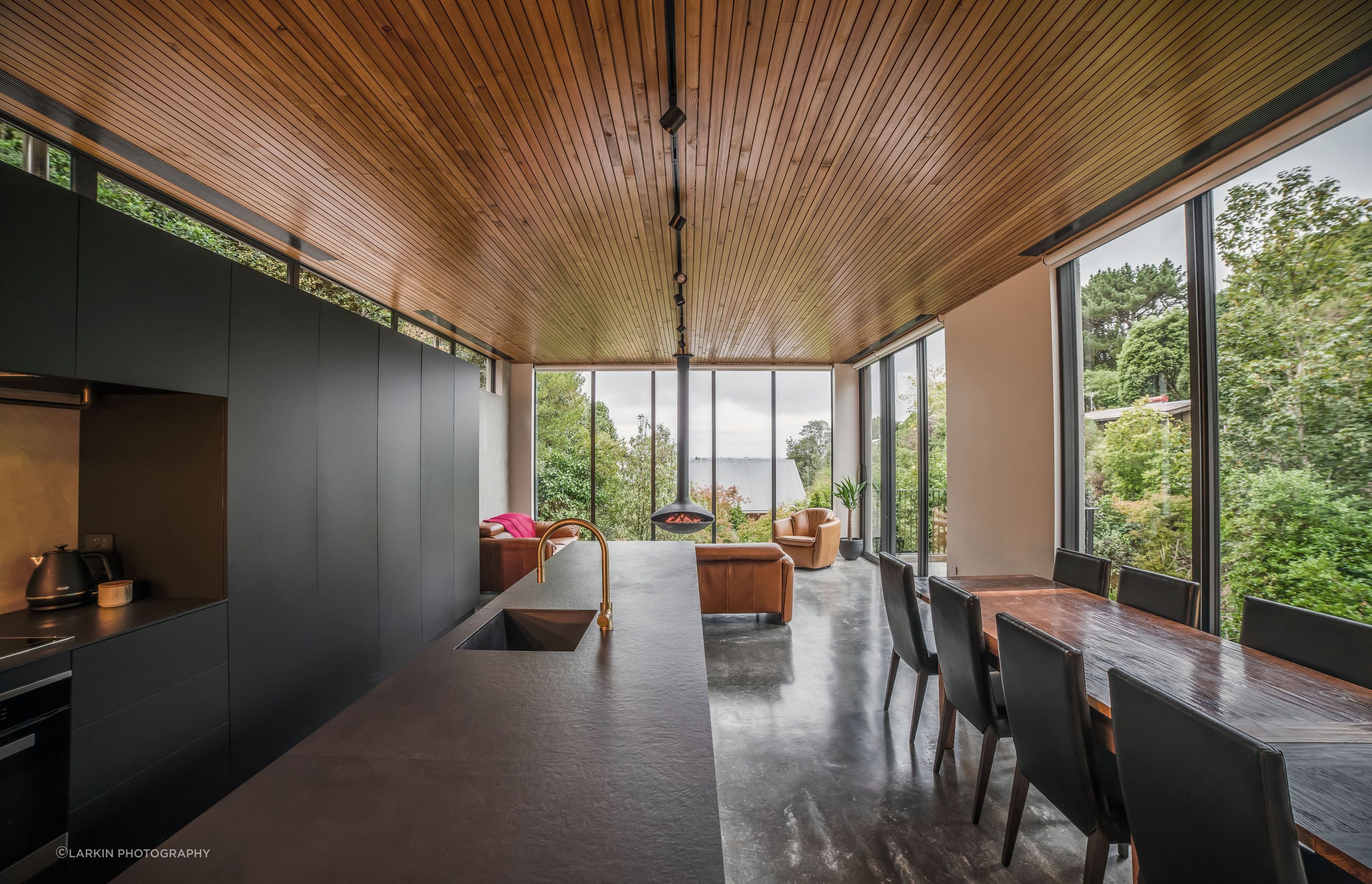 Upstairs, full-height glazing creates the experience of sitting amongst the treetops.