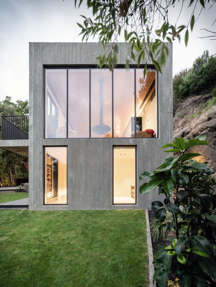 The brutalist concrete form is punctuated with large glass panels.