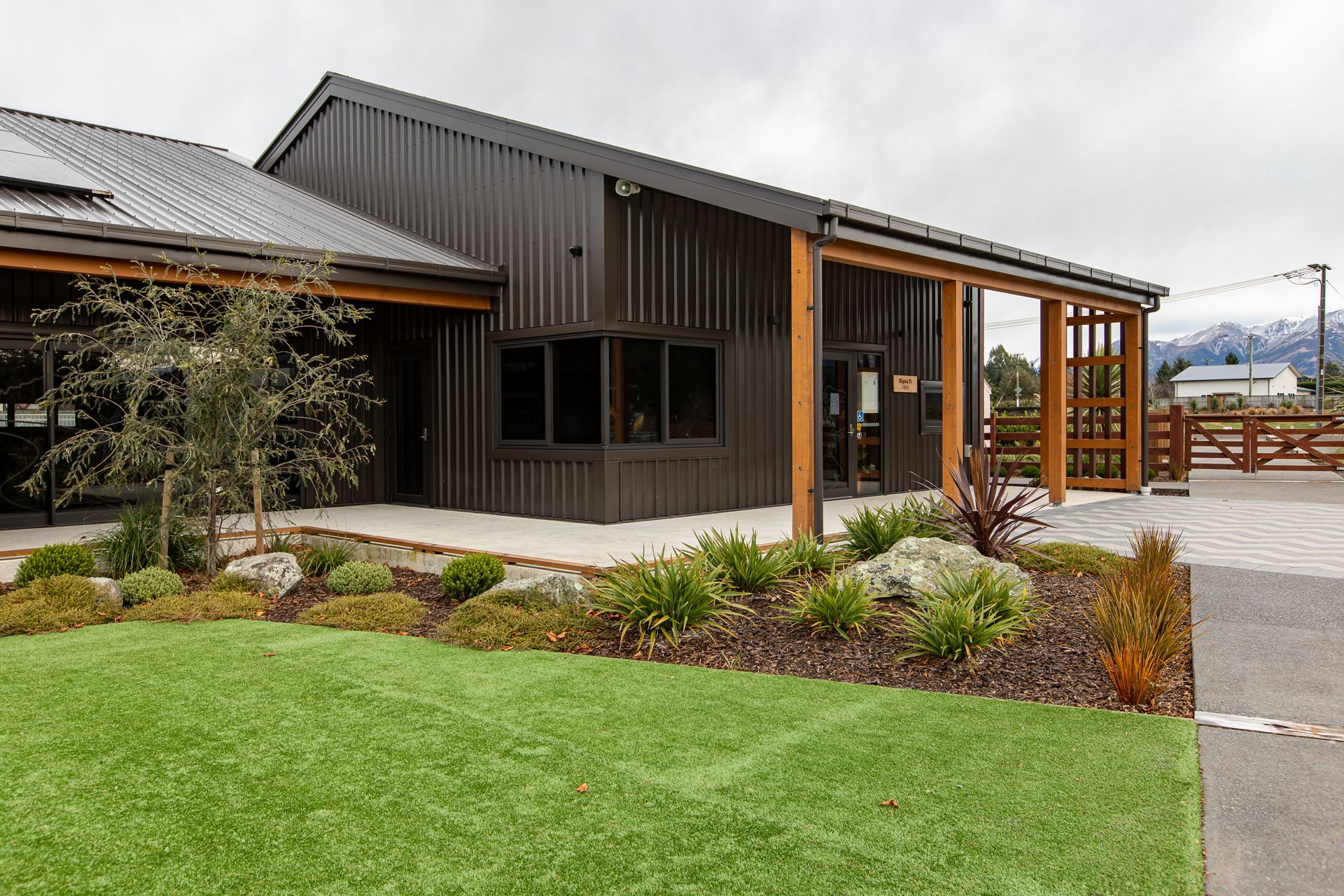The macrocarpa detailing of the verandas contrasts beautifully with the dark metal cladding of the buildings.