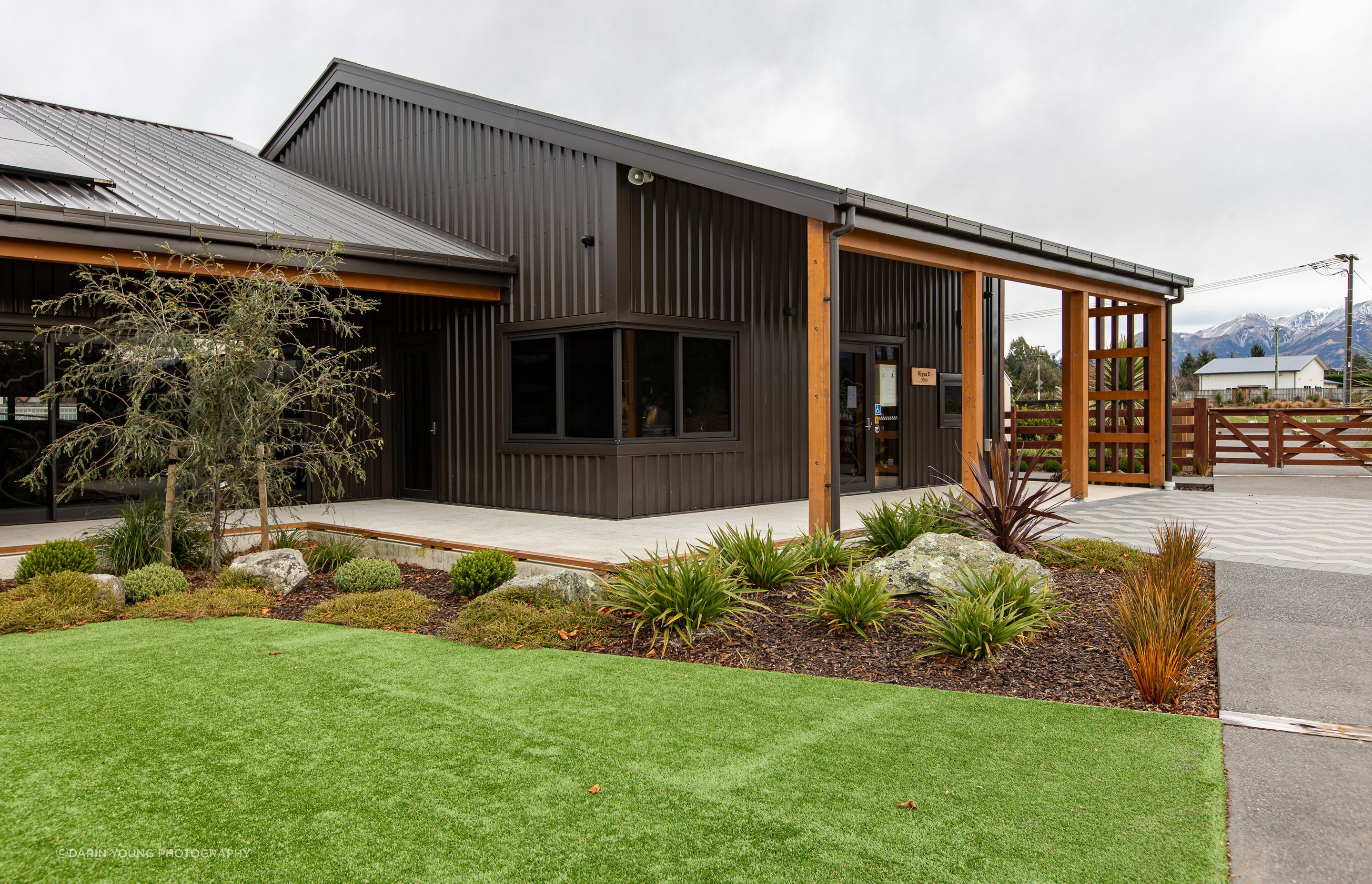 The macrocarpa detailing of the verandas contrasts beautifully with the dark metal cladding of the buildings.