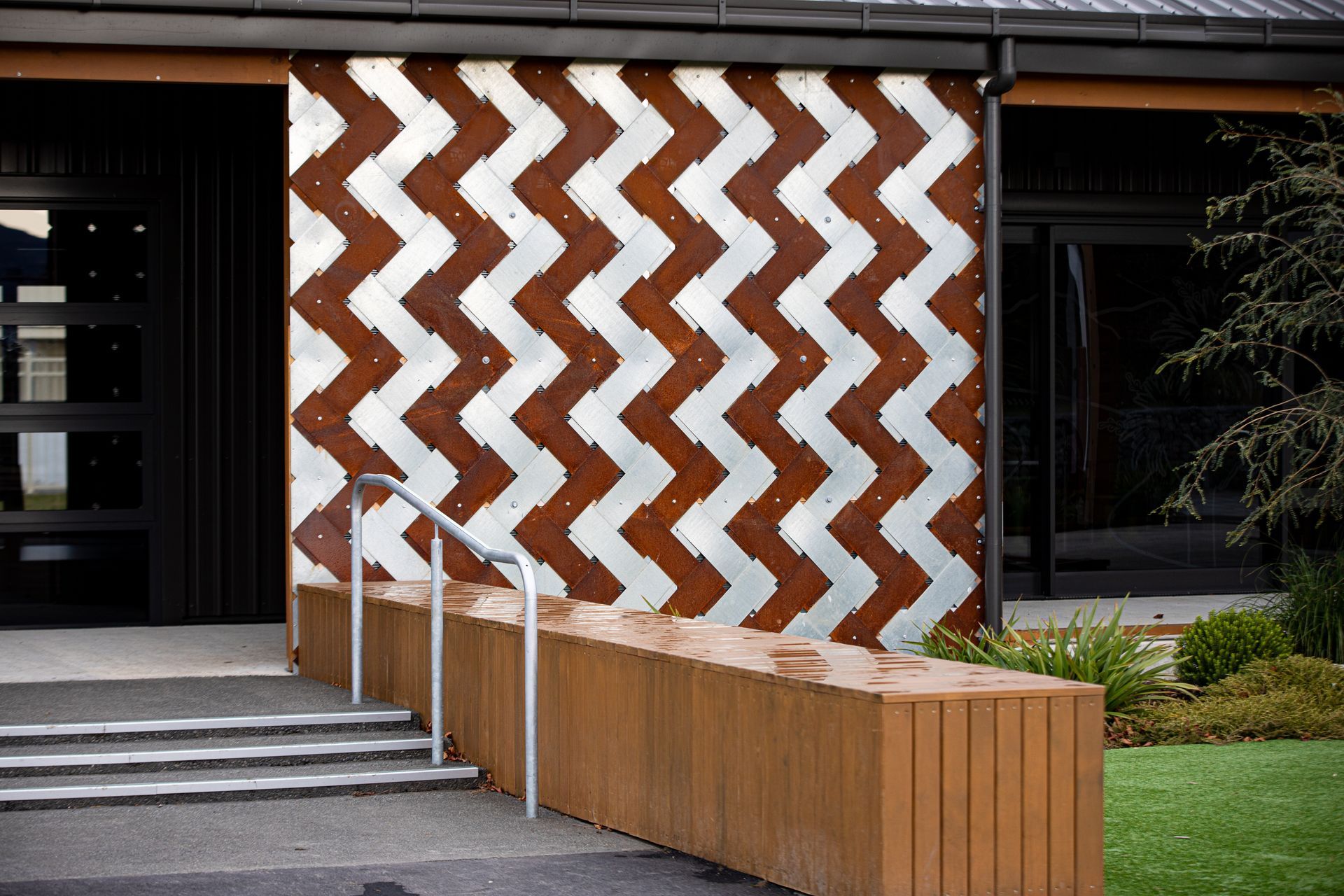 A Corten and stainless steel interwoven panel reflects the leaves of the cabbage tree.