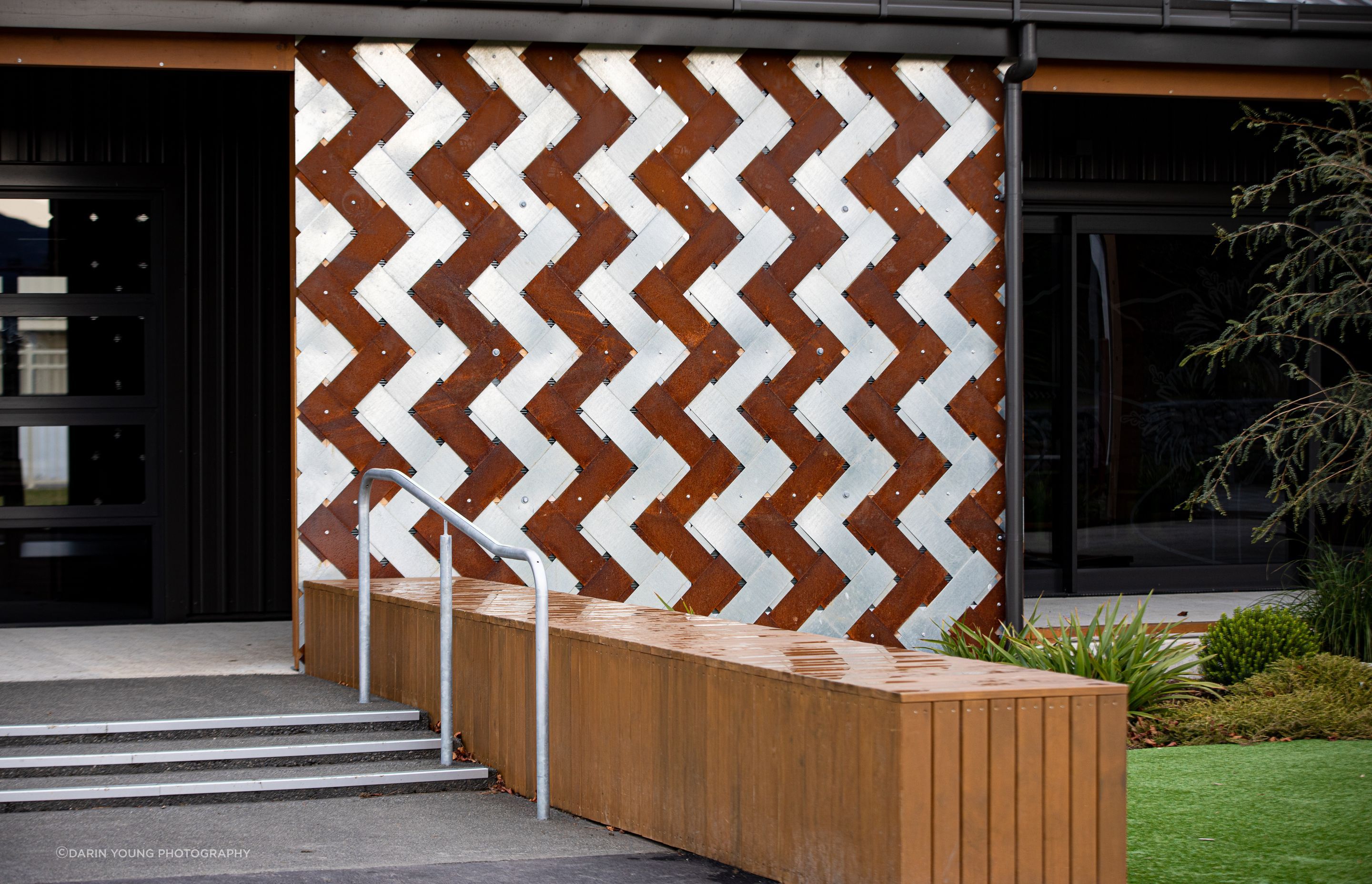 A Corten and stainless steel interwoven panel reflects the leaves of the cabbage tree.