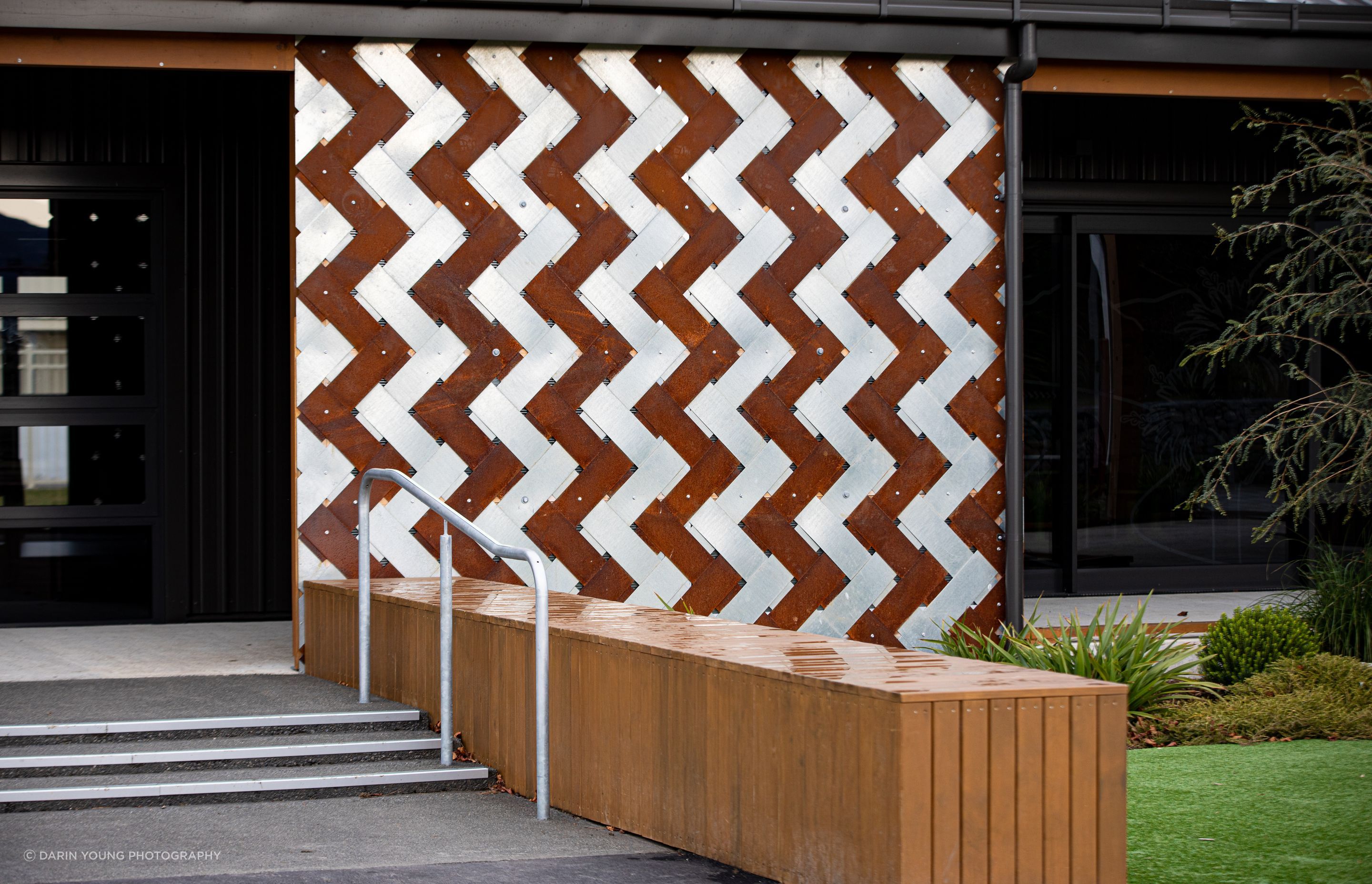A Corten and stainless steel interwoven panel reflects the leaves of the cabbage tree.