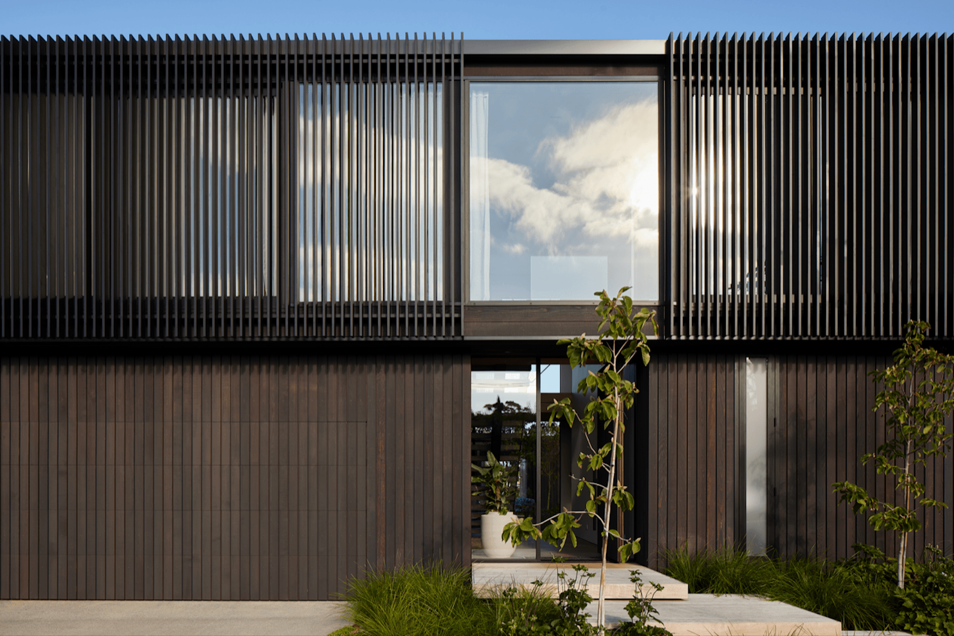 Vertical cedar cladding and aluminium fins create a dramatic visual.