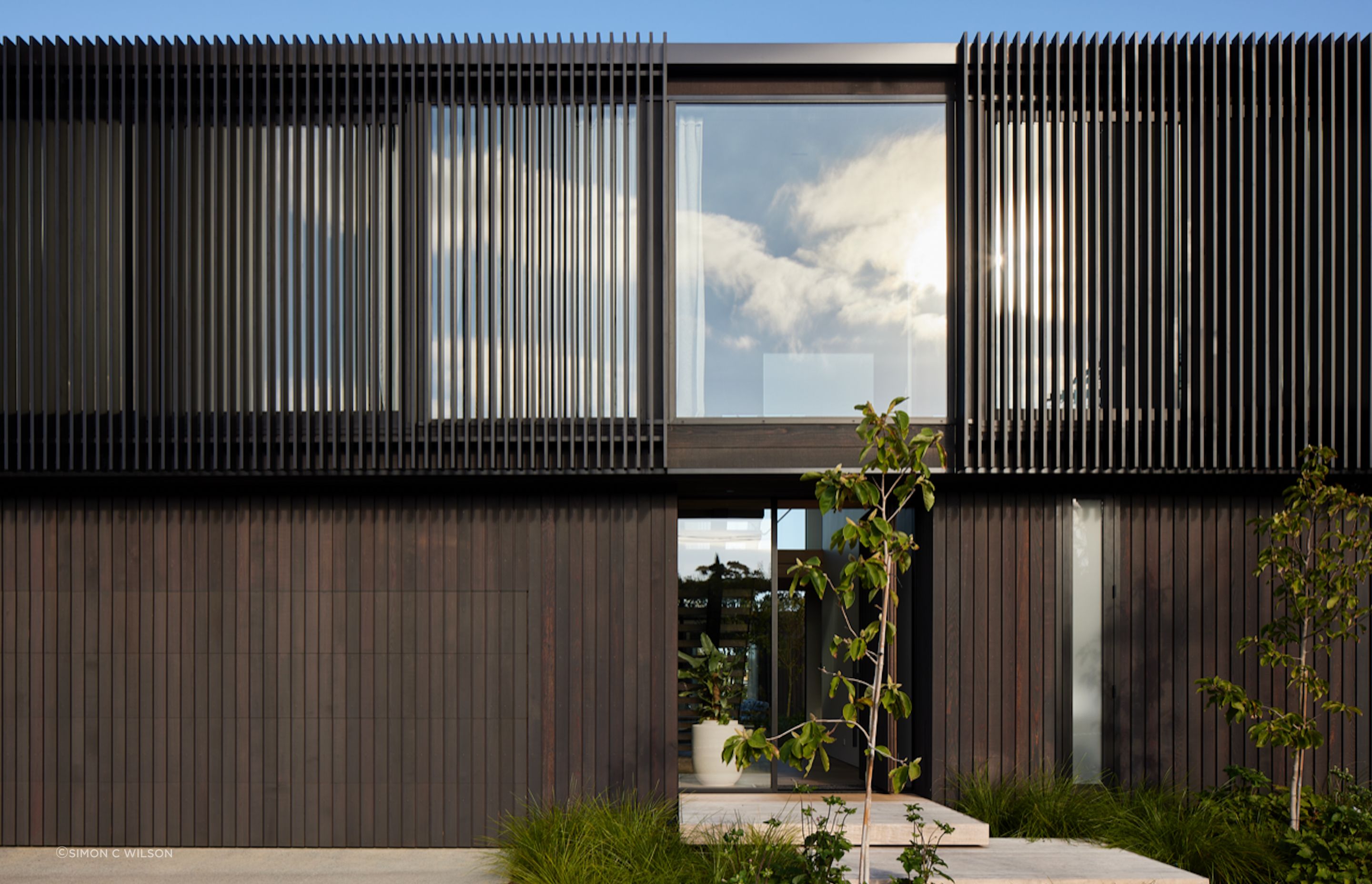 Vertical cedar cladding and aluminium fins create a dramatic visual.