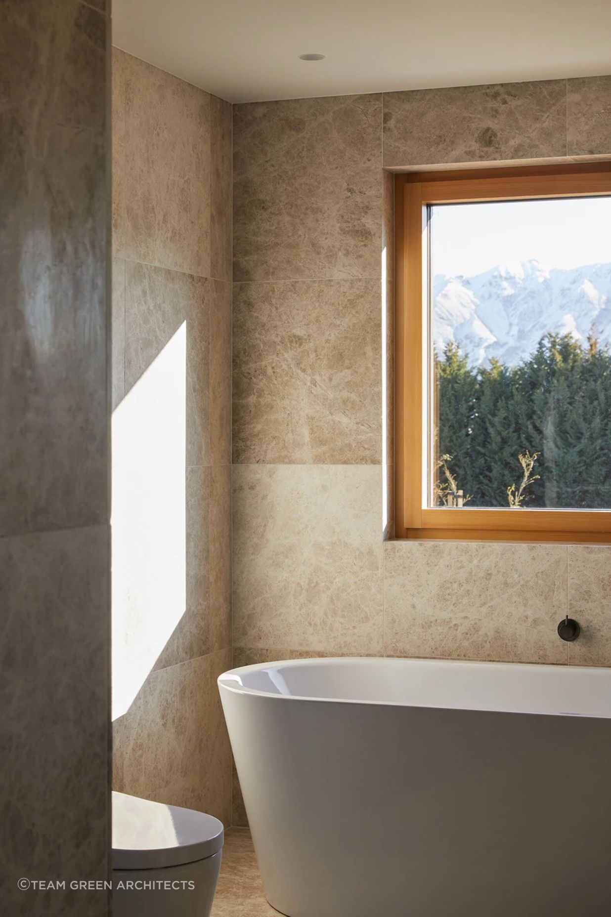 Marble stone tiles meet aged iron tapware in the bathroom.