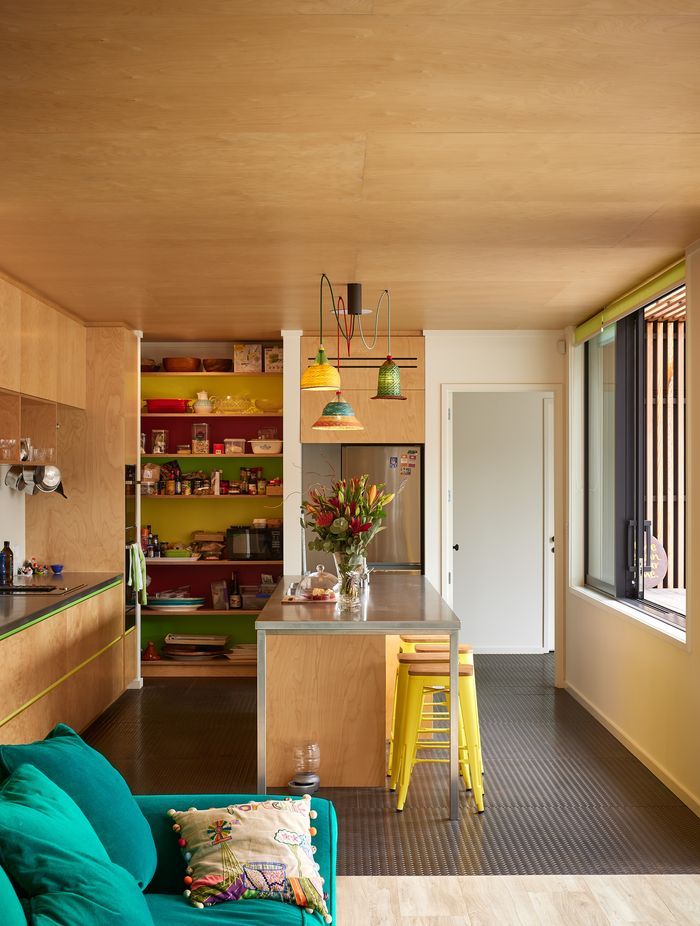 The kitchen features colourful tiles and light shades made from recycled plastic bottles for a playful, lighthearted feel.