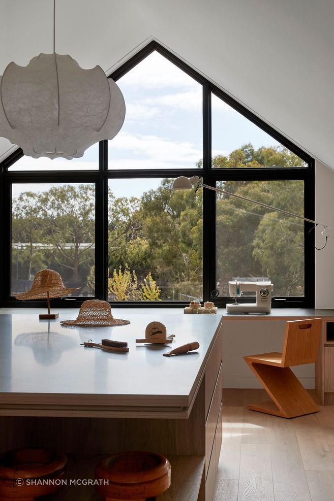 The gabled window opposite the kitchen mirrors the same architectural form as the 4.2 metres high and 6.1 metres wide window installed above the kitchen benchtop.