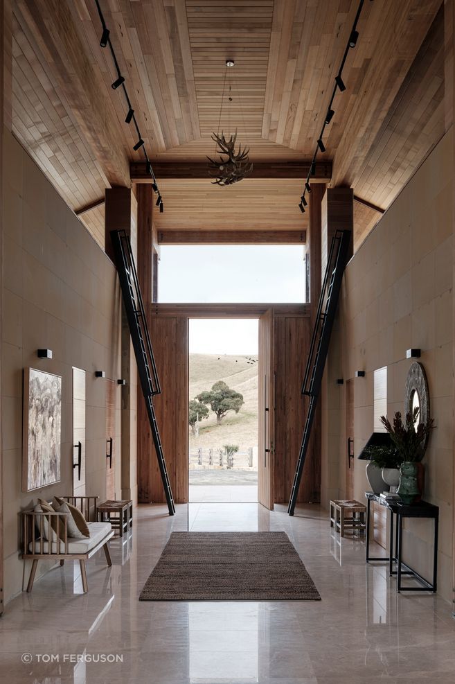 The ceiling height reaches seven metres at the entrance. Ladders on either side of the front door lead to hidden mezzanine-level rooms.