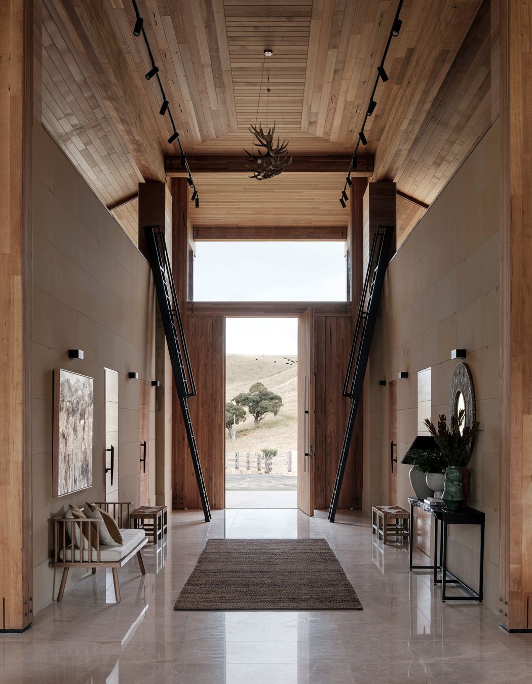 The ceiling height reaches seven metres at the entrance. Ladders on either side of the front door lead to hidden mezzanine-level rooms.