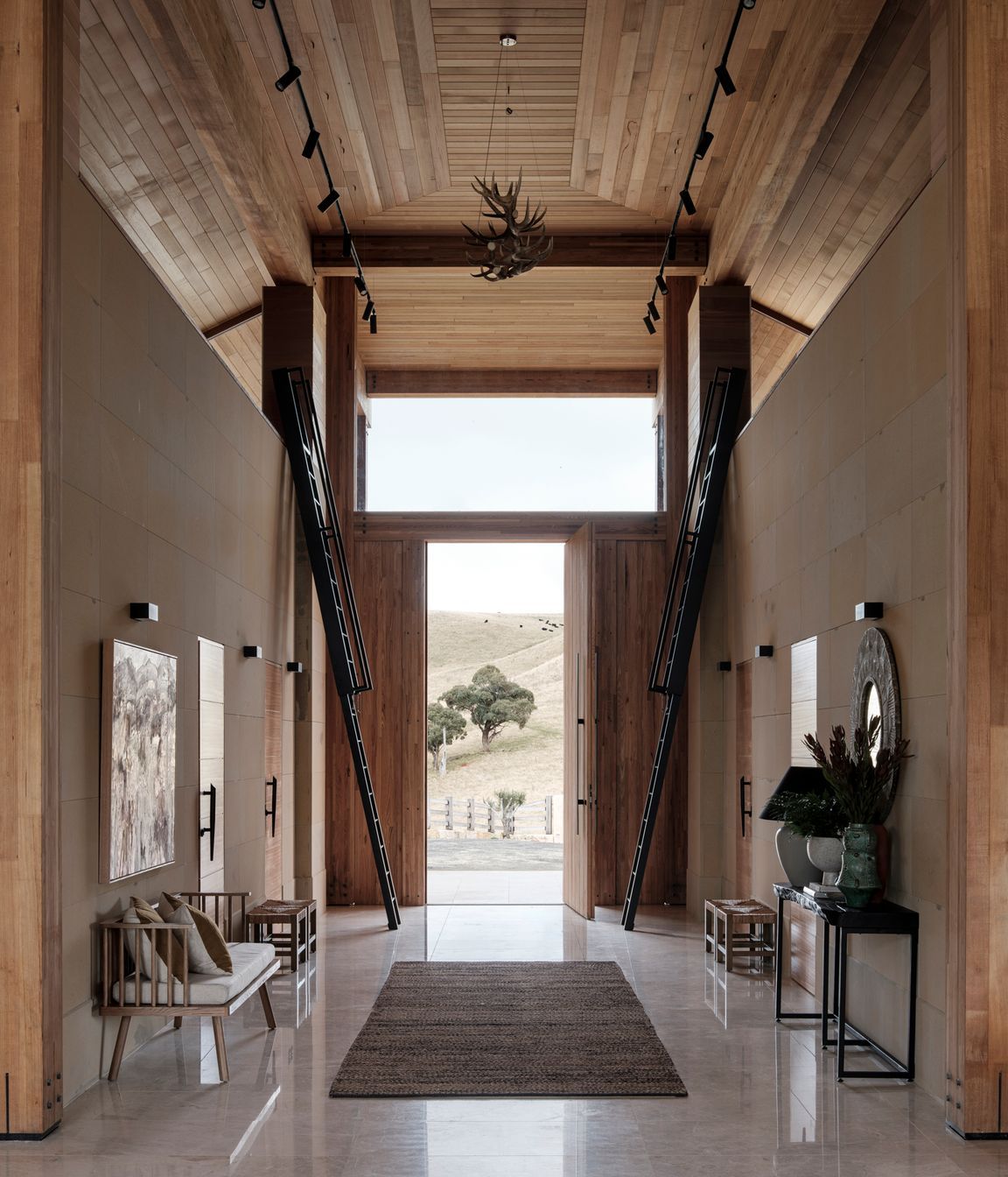 The ceiling height reaches seven metres at the entrance. Ladders on either side of the front door lead to hidden mezzanine-level rooms.