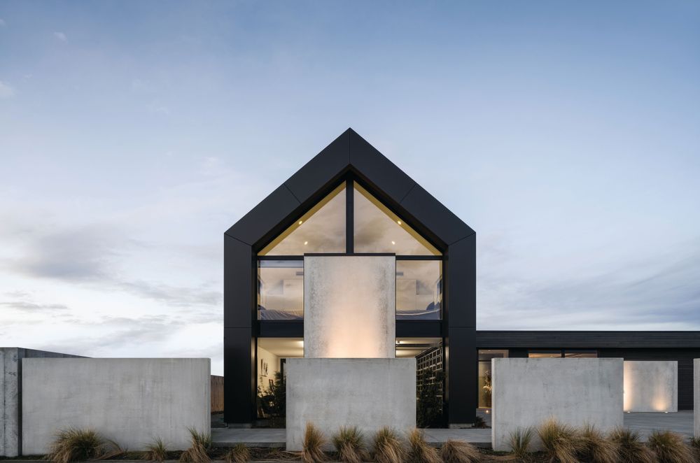 The two-storey gabled form uses vertical cladding, while the single-storey living wing is clad horizontally in cedar.