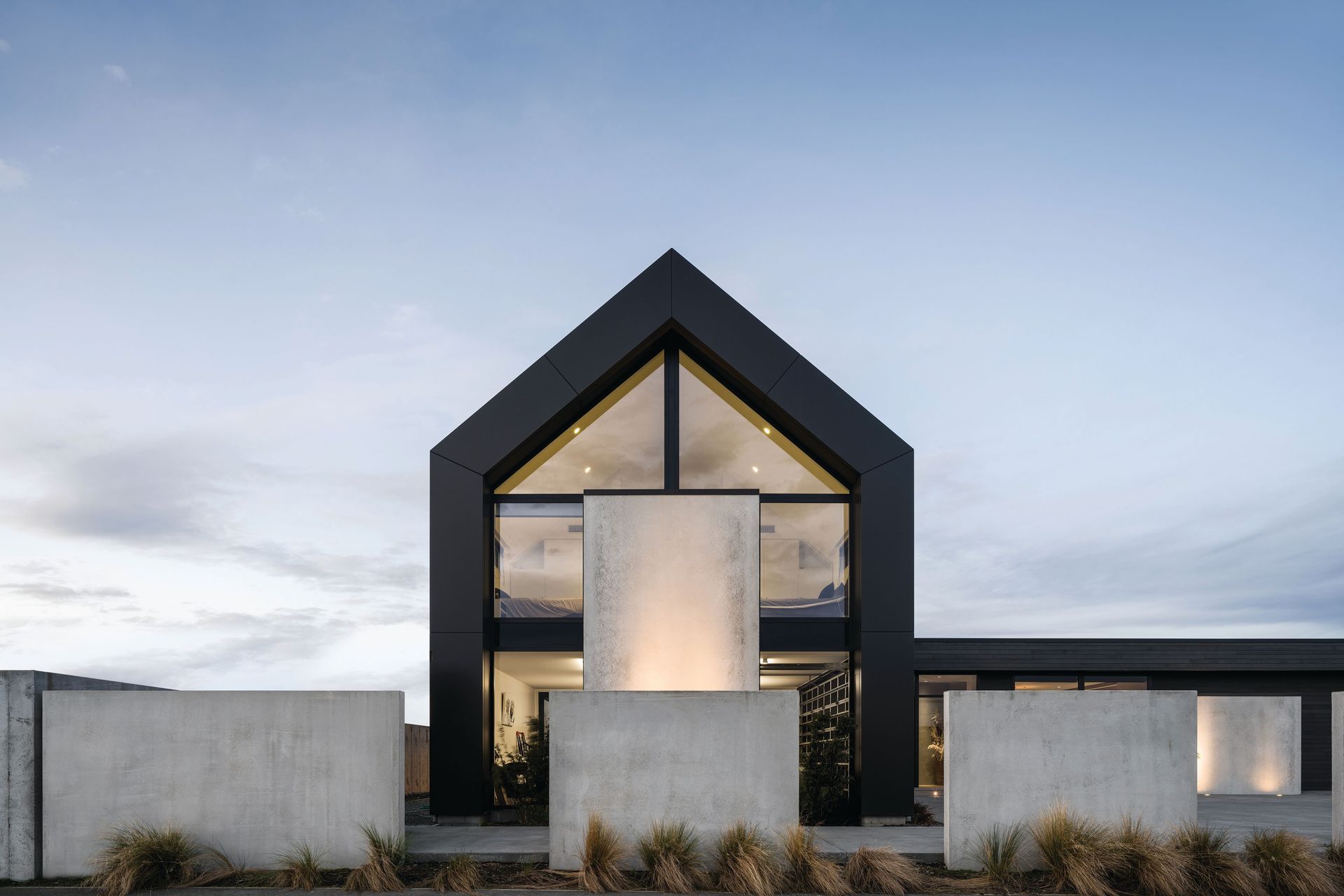 The two-storey gabled form uses vertical cladding, while the single-storey living wing is clad horizontally in cedar.