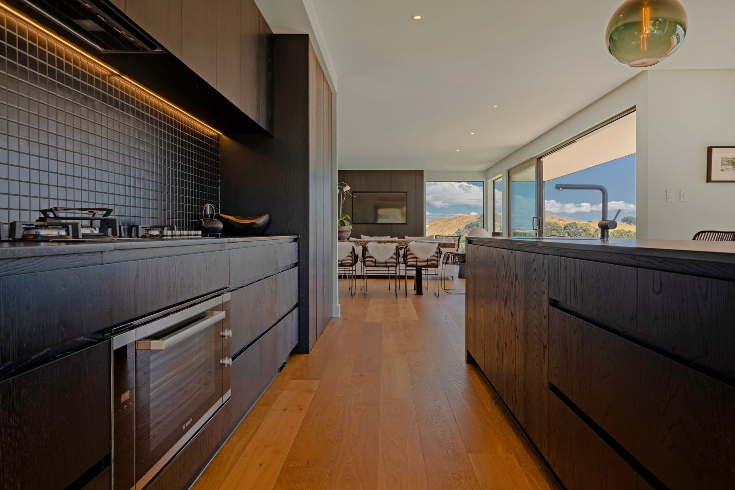 The kitchen takes notes from the home's exterior with a dark colour palette.