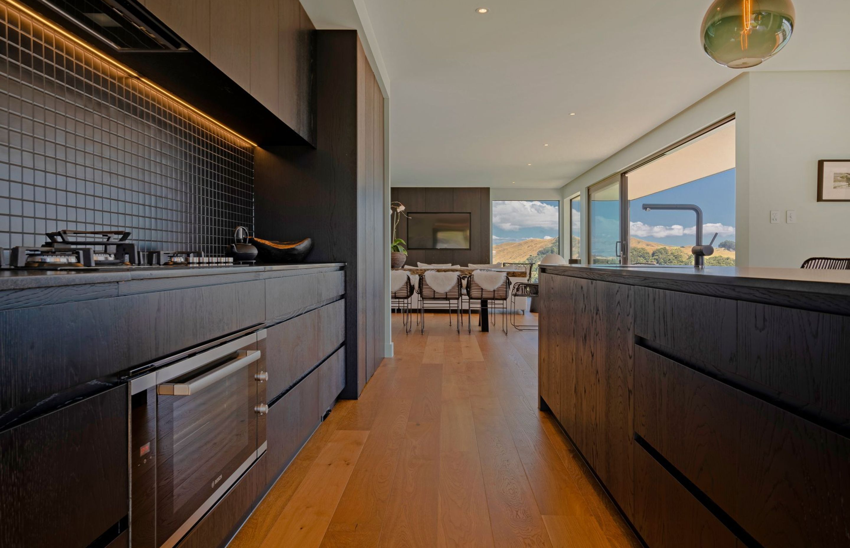 The kitchen takes notes from the home's exterior with a dark colour palette.