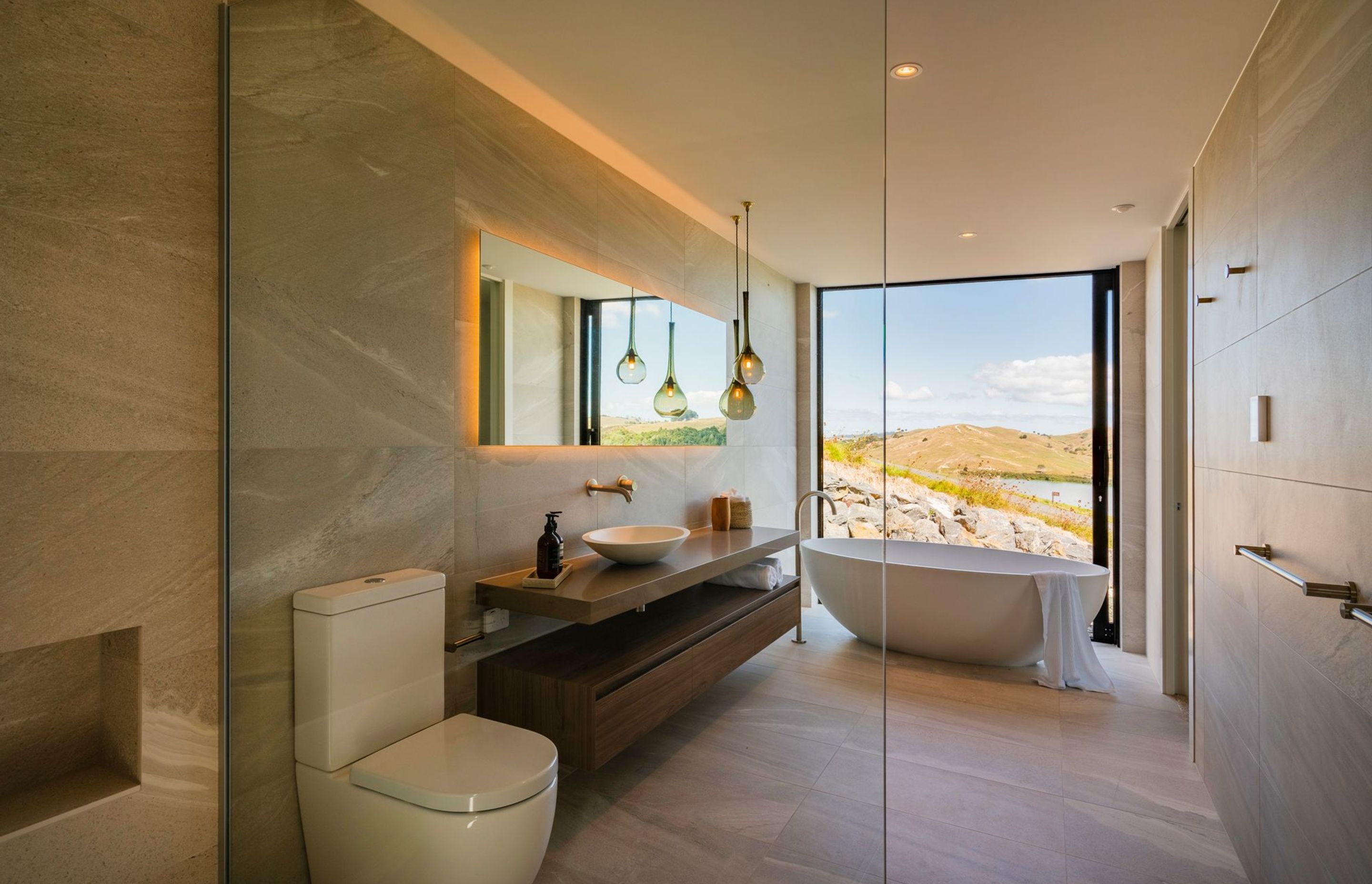 Every detail has been considered in the bathroom, with a bespoke vanity, large format tiles and a Waterware bathtub that overlooks the stunning view.