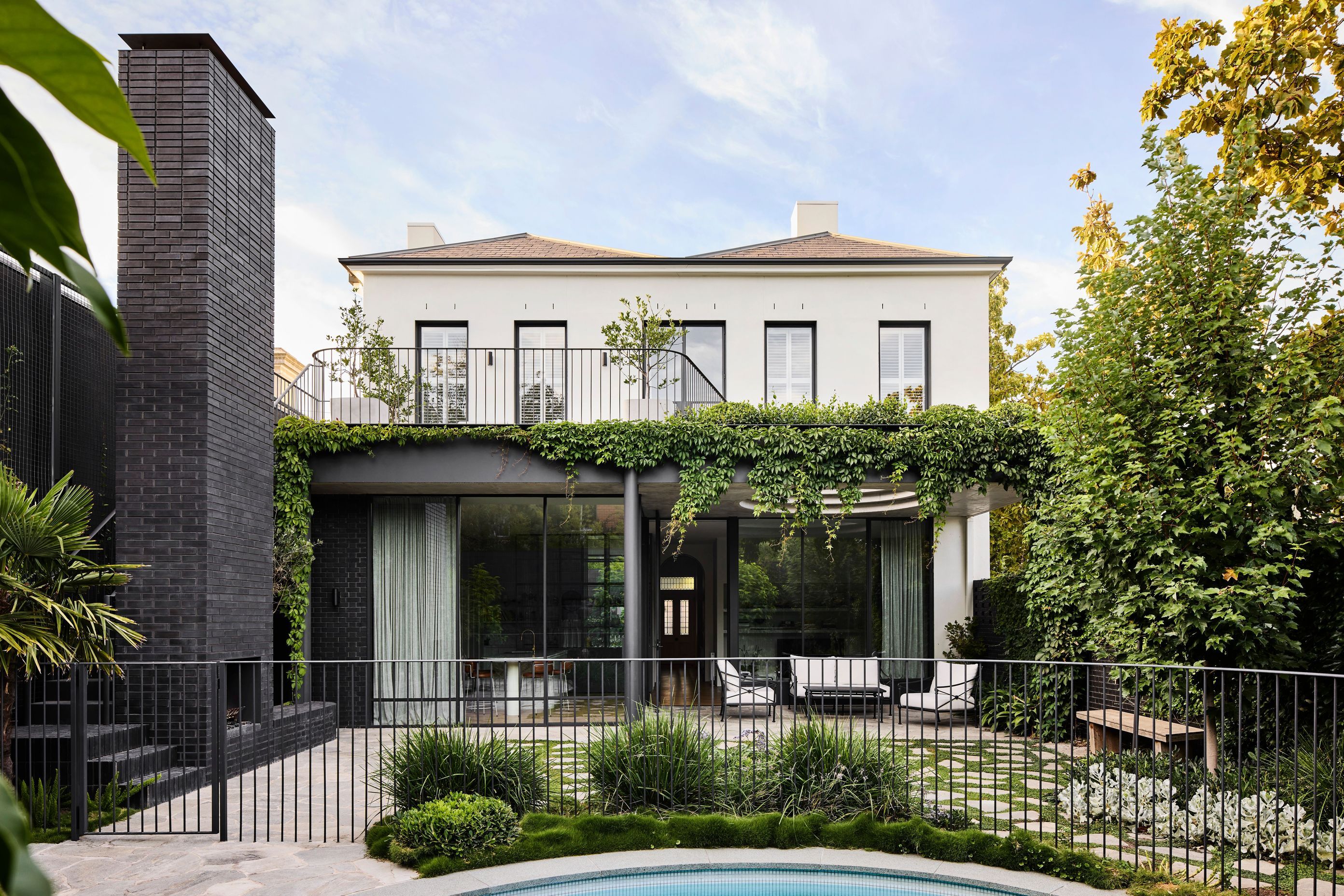 Brick and stone wrap the backyard and integrate seamlessly with the materiality of the original home.