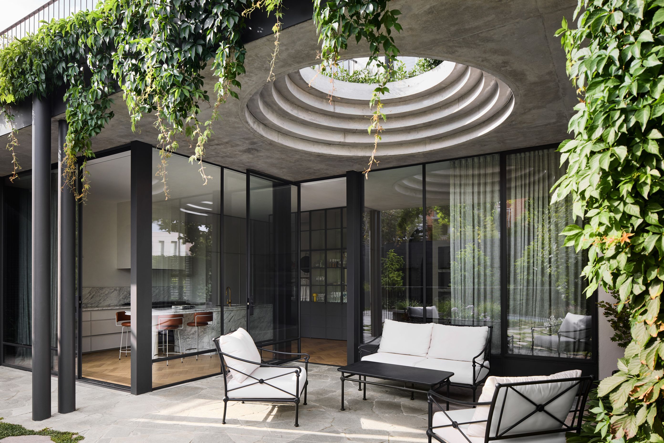 A series of sculptural concrete circles provides a peep hole of sun and light into the exterior courtyard.