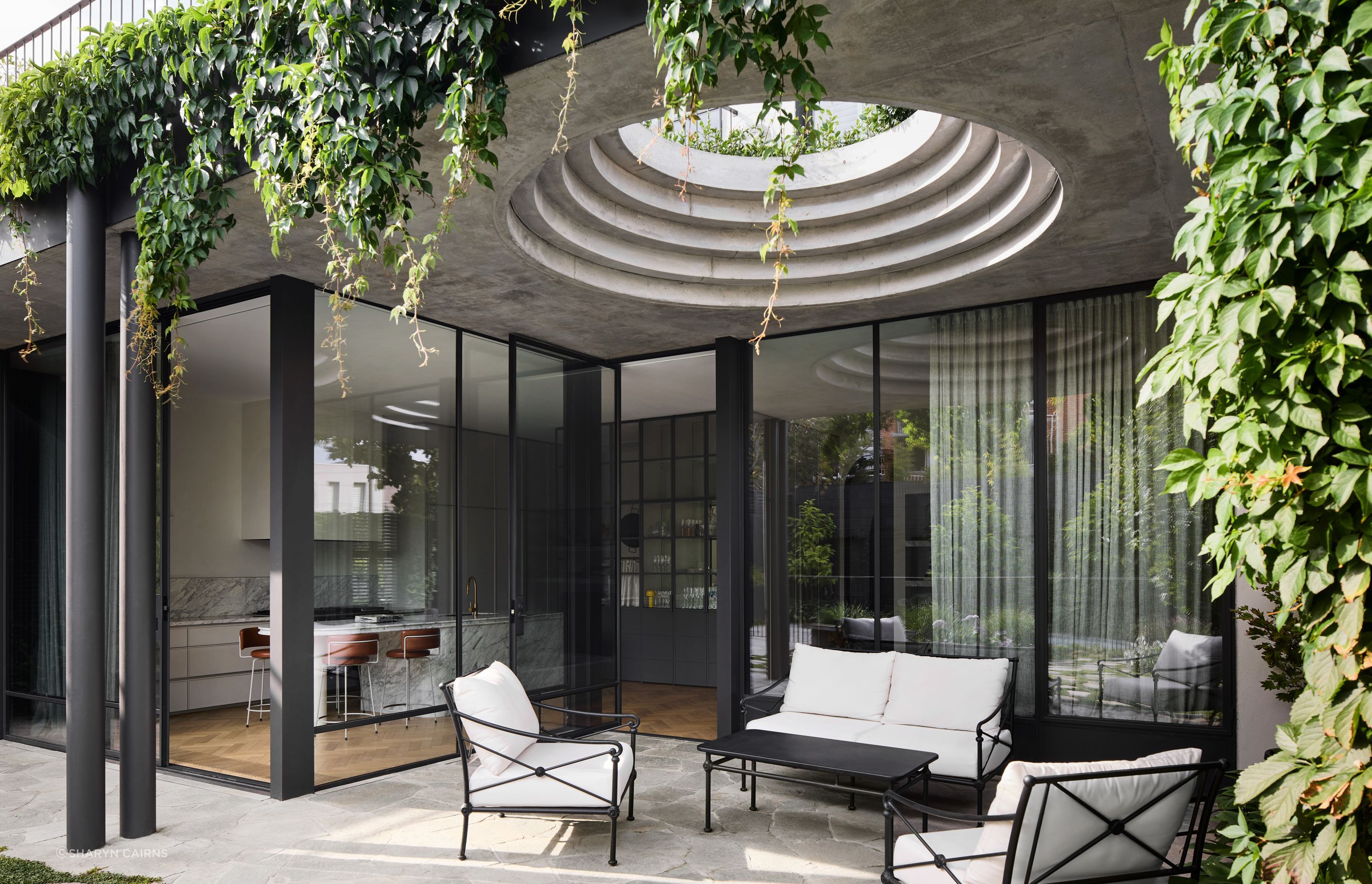 A series of sculptural concrete circles provides a peep hole of sun and light into the exterior courtyard.