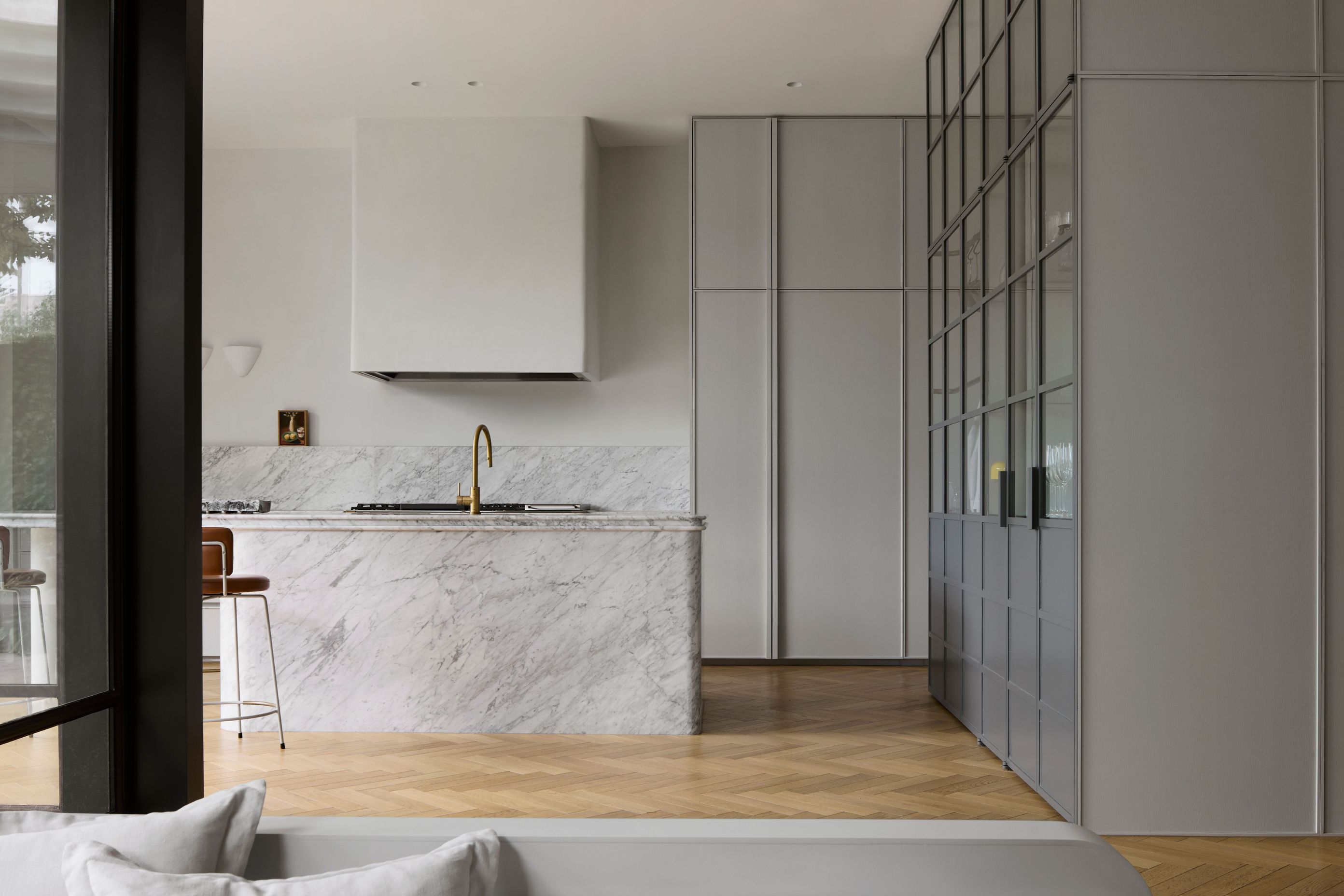 The kitchen is reimagined in soft grey tones and marble.