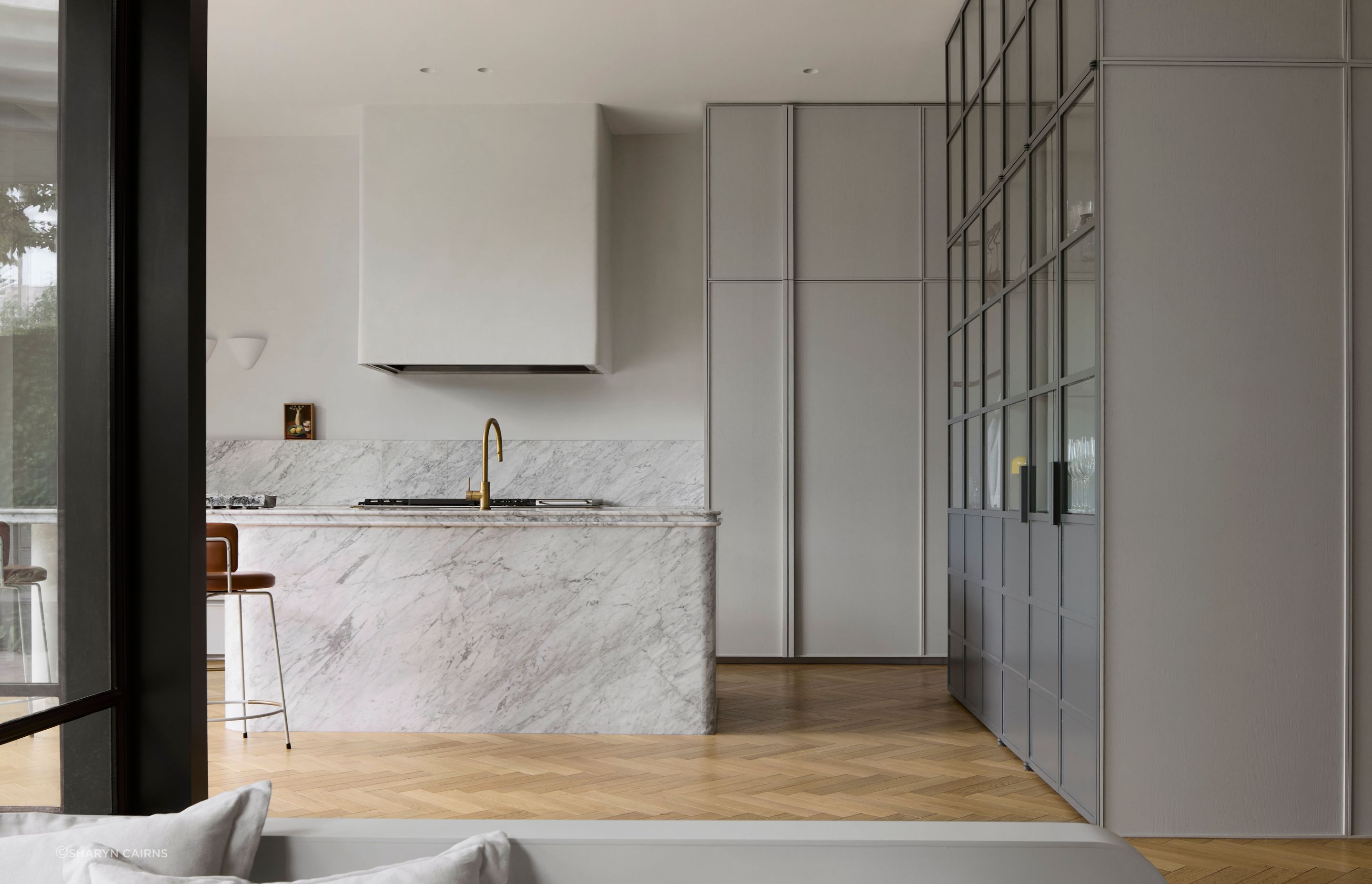 The kitchen is reimagined in soft grey tones and marble.