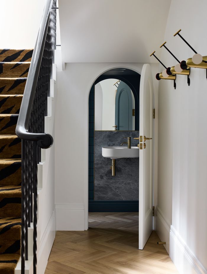 The curves of the exterior are carried into the interior, such as in these under-stairs powder room.