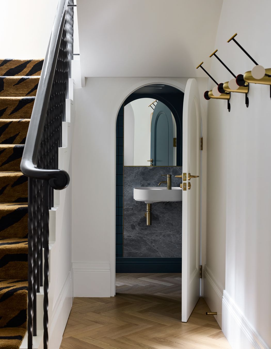 The curves of the exterior are carried into the interior, such as in these under-stairs powder room.