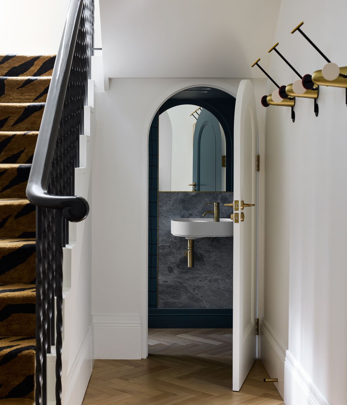 The curves of the exterior are carried into the interior, such as in these under-stairs powder room.