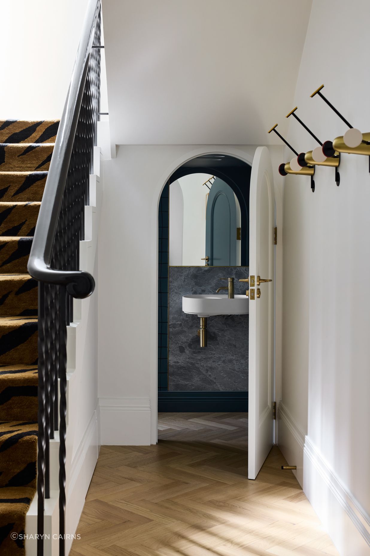 The curves of the exterior are carried into the interior, such as in these under-stairs powder room.