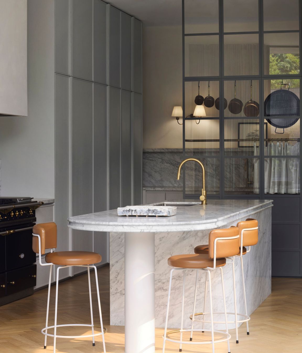Curves are repeated in the shape of the kitchen island, lending a softness to the space.