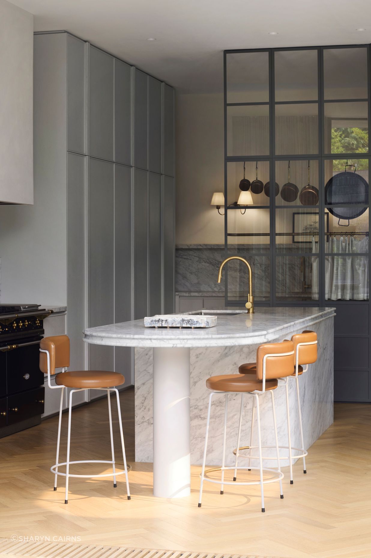 Curves are repeated in the shape of the kitchen island, lending a softness to the space.