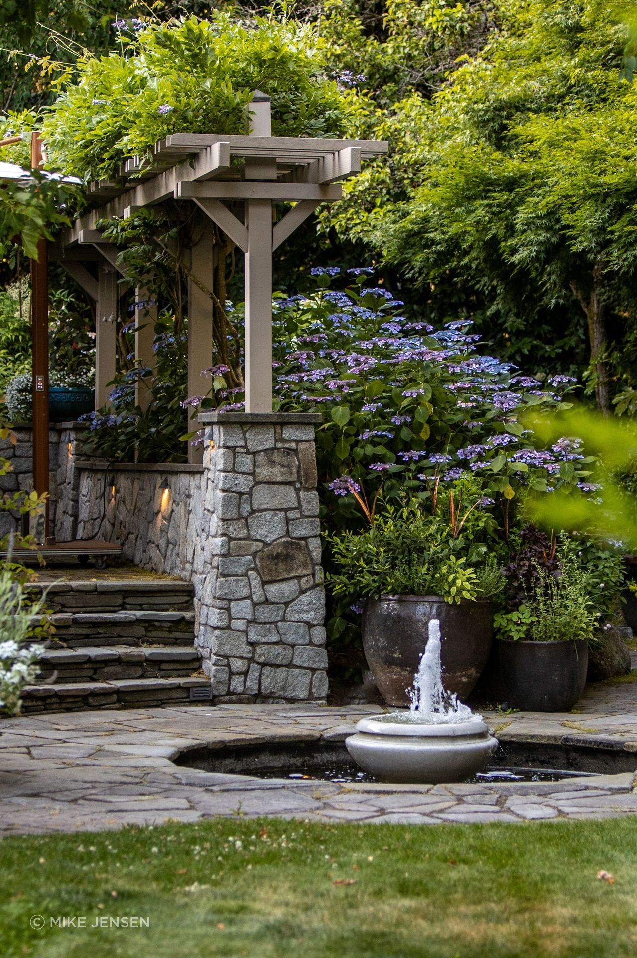 For retaining walls, dry-stacked granite with broken faces were used to contrast with the paths made of smooth bluestone.