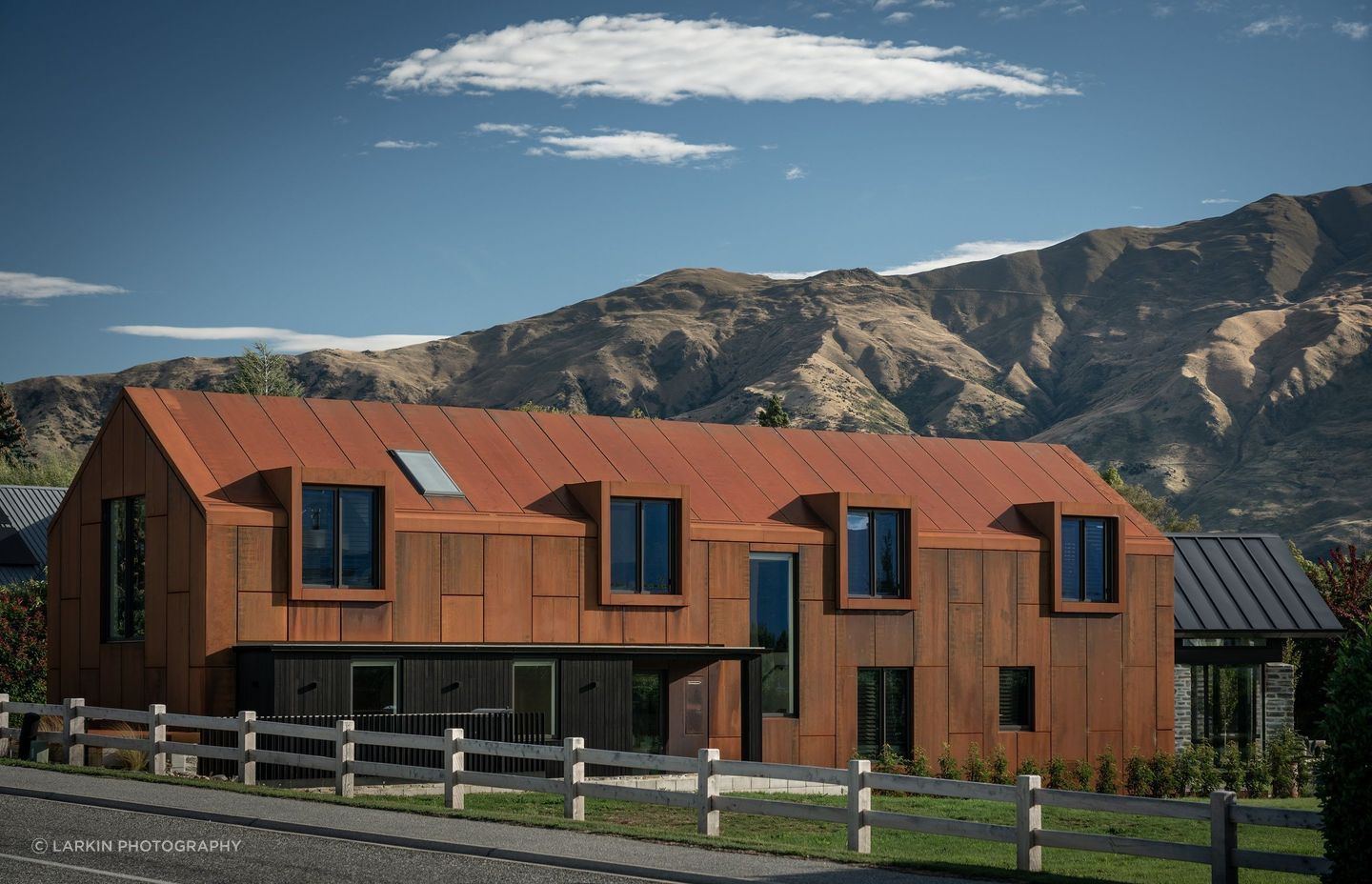 The large corten gable form echoes the form of the mountain ranges beyond.