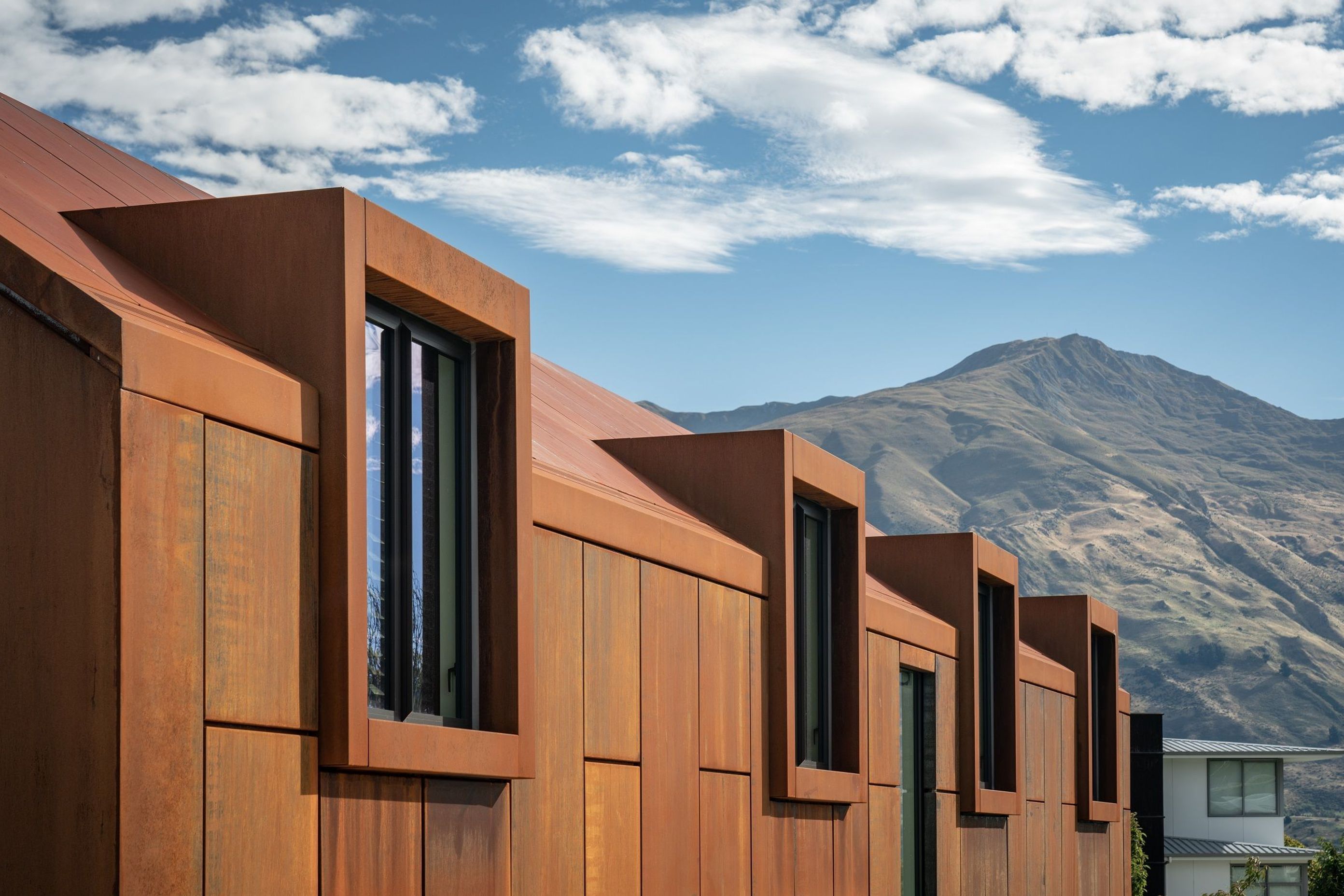 The rich, rusty tones of the corten give warmth to a monolithic building form.