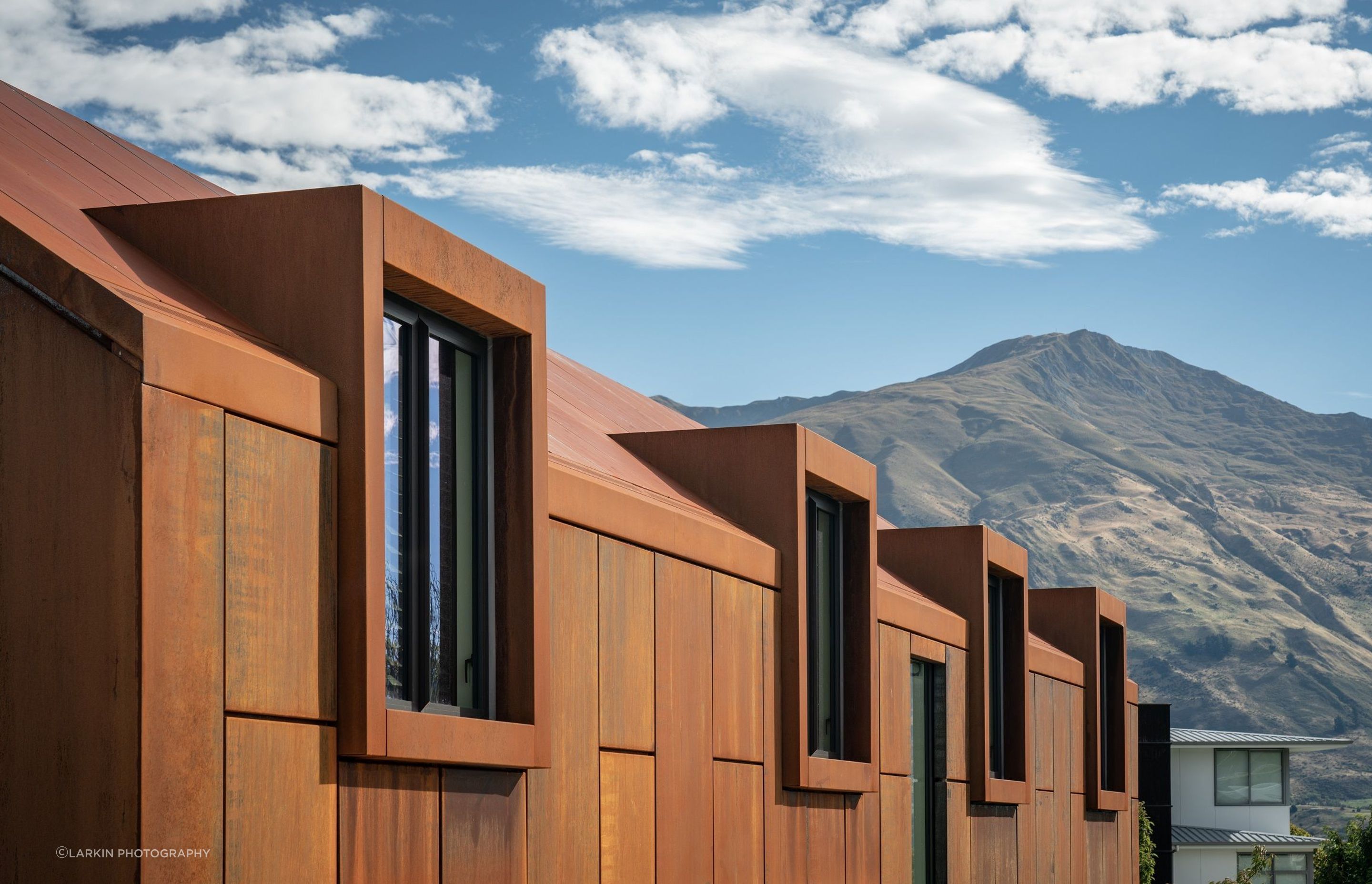 The rich, rusty tones of the corten give warmth to a monolithic building form.