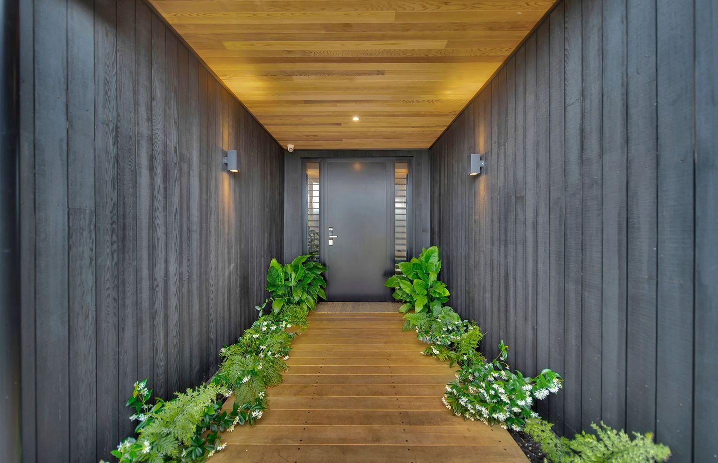 The contrast of stained and natural cedar in the entrance gives a glimpse of what to expect inside the home.