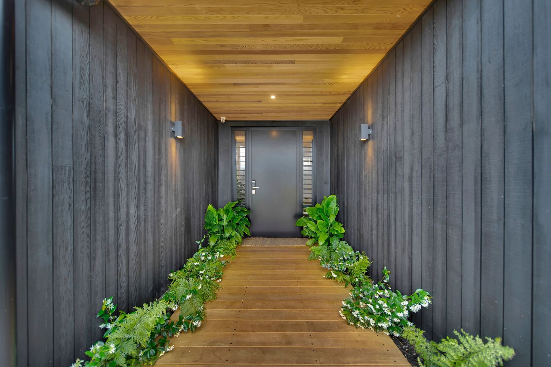 The contrast of stained and natural cedar in the entrance gives a glimpse of what to expect inside the home.